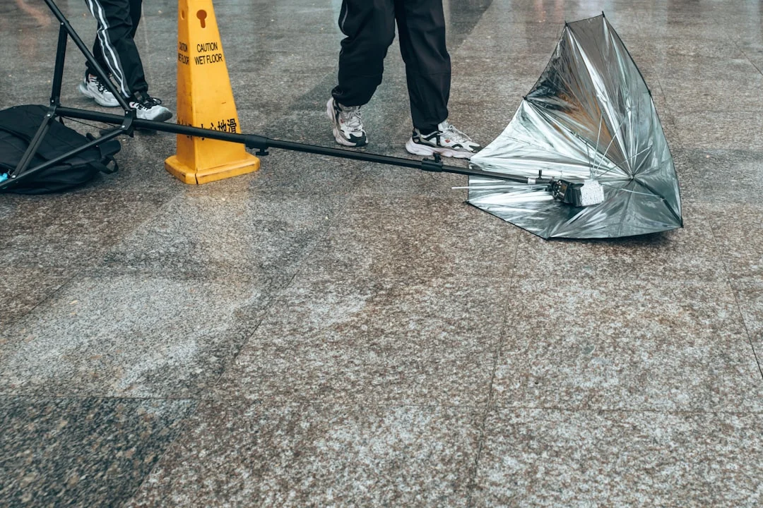 A professional cleaner wearing protective gear vacuuming the floor in a contemporary living room.